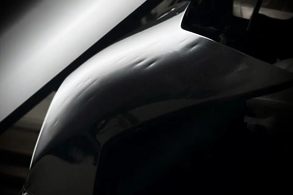 Paintless dent repair before and after on a black panel — Calgary — before