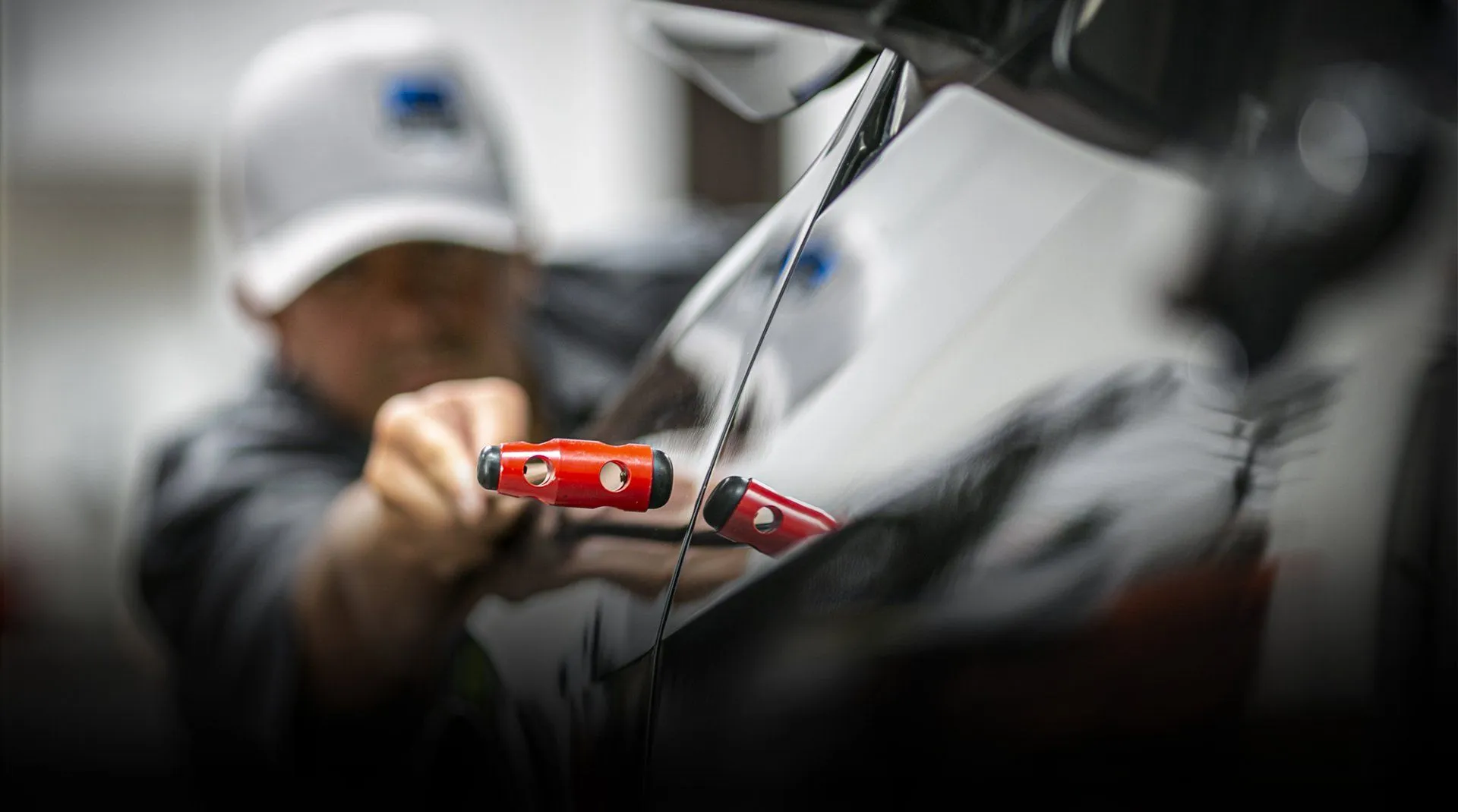 Paintless dent repair in progress — glue-pull tabs on a panel, Calgary
